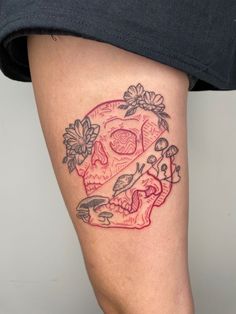 a woman's thigh with a skull and flowers on it