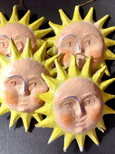 four sun faces are made out of clay