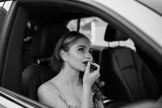 a woman sitting in the back seat of a car talking on a cell phone