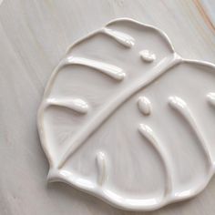 a white plate with a leaf design on it