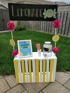 the lemonade stand is decorated with pink and yellow flowers