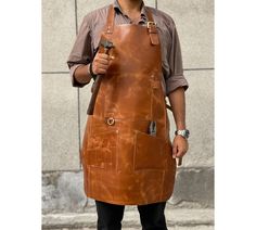 "We promise you that the apron will arrive as per the deadline given by you, even if its less than a week. 15% OFF ON 3 or more aprons - use coupon code - 15PERCENTOFF Enjoy FREE PERSONALISATION on 2 or more aprons! Each piece is beautifully handmade with full grain leather with a warranty of a lifetime, its simply a high quality leather sourced directly from leather tanneries. KEY FEATURES- Spacious front two pockets along with 5 compartments especially for your tools, adjustable neck strap and Woodworking Apron, Work Aprons, Bbq Apron, Leather Apron, Custom Aprons, Aprons For Men, Kitchen Crafts, Chef Apron, Personalised Gifts For Him