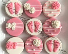 pink and white decorated cookies with baby's feet, roses and ribbons on them