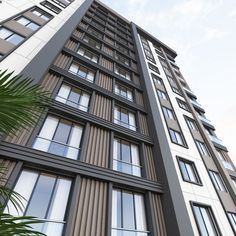 a tall building with lots of windows next to palm trees