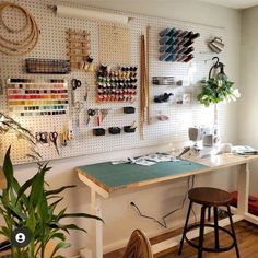 a sewing room with lots of crafting supplies on the wall and hanging pegs