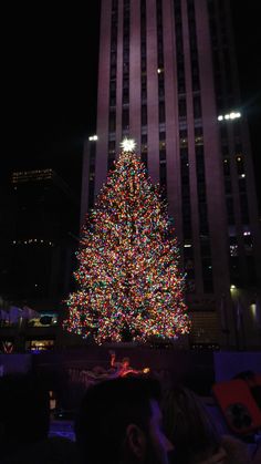 a large christmas tree is lit up in the city