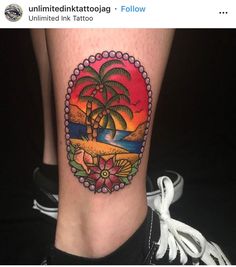 a tattoo on the leg of a woman with a sunset and palm tree in the background