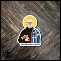 the saint maximusmilan kolbe sticker is shown on a wooden surface