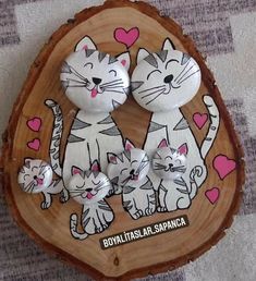 two white cats with pink hearts are sitting on a wood slice that has been painted to look like they are holding hands