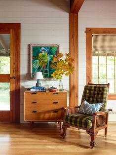 a living room filled with furniture and a wooden dresser next to a window covered in blinds