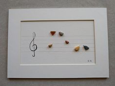 a musical note with five different colored rocks in it