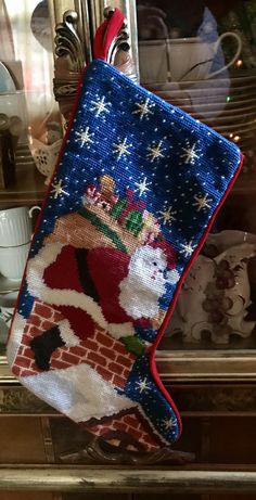 a christmas stocking hanging from the side of a fireplace with a santa clause on it