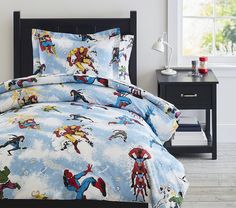 the comforter is made up with cartoon characters on blue and white bed linens