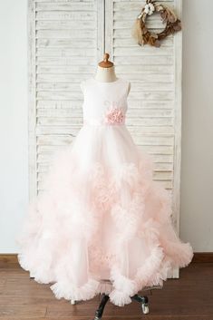 a dress on a mannequin stand in front of a white door with shutters