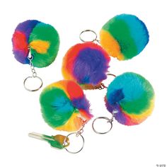 four multicolored pom poms with keychains attached to each other