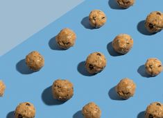 chocolate chip cookies arranged in rows on a blue and light blue background with shadows from them