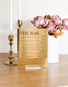 the bar sign next to two candles and flowers