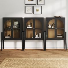 a living room with two black bookcases and pictures on the wall