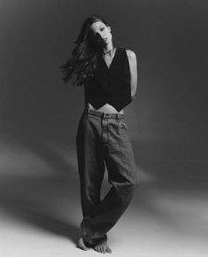 black and white photograph of a woman in high waisted jeans with her hair blowing in the wind