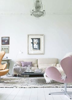 a living room filled with furniture and a painting hanging on the wall above it's doorway