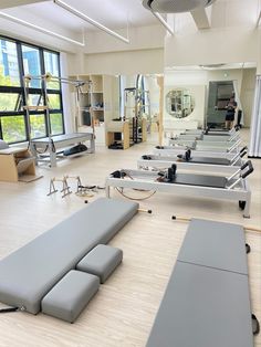 an empty gym with rows of benches in front of large windows and lots of equipment