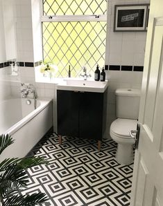 a bathroom with black and white tile flooring next to a bathtub, toilet and sink