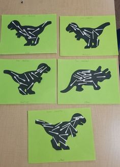 four pieces of paper cut to look like dinosaurs