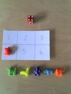 two dices and four different colored plastic animals on a table