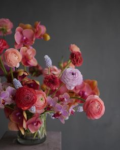 a vase filled with lots of different colored flowers