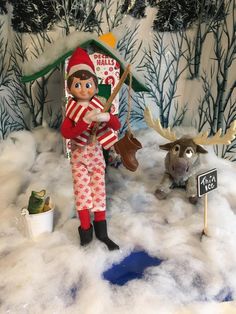 the elf is playing with his reindeer in the snow