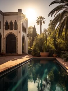 the sun shines brightly through palm trees in front of a large house with a swimming pool