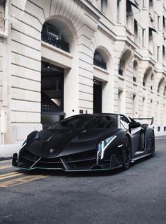 a black sports car parked in front of a building on the side of a street