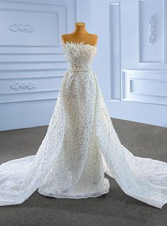 a white wedding dress on display in a room