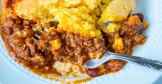 a close up of a plate of food with meat and cornbread casserole