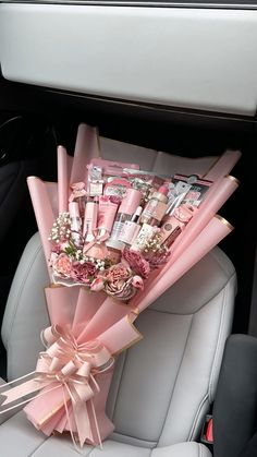 a bouquet of lipstick and flowers in the back seat of a car with pink ribbon