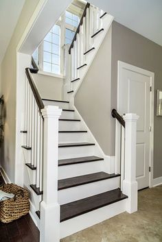 the stairs in this house are painted white and black with wood treading on them