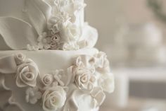 a wedding cake with white flowers on it's side and frosting around the edges