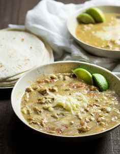 two bowls of soup with tortillas on the side