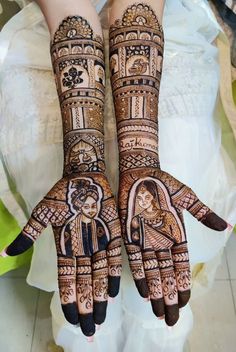 two hands with henna designs on them