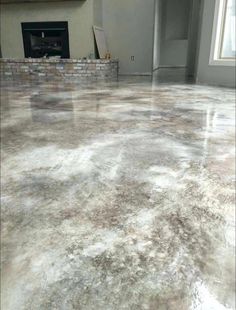 an empty room with a fireplace and large tile flooring area in the middle of it