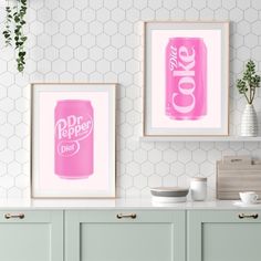 two pink cans are hanging on the wall next to some green cupboards and white tiles