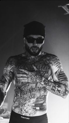 a man with tattoos on his chest and arms