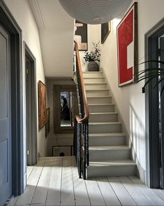 a staircase leading up to the second floor in a house with white walls and wood floors