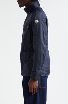 A quartet of large patch pockets inspired by field jackets enhance the utilitarian appeal of this jacket crafted of Moncler's water-repellent rainwear fabric. A stowaway hood and internal drawstring waist add to the functionality of the adventure-ready piece. Two-way front-zip closure with button storm placket Stand collar; stowaway hood Adjustable snap-tab cuffs Chest snap-flap patch pockets; front snap-flap patch pockets Internal drawcord waist 100% polyamide Machine wash, line dry Imported De Functional Utility Jacket With Cargo Pockets For Work, Functional Outerwear With Multiple Pockets For Travel, Functional Travel Outerwear With Multiple Pockets, Utility Windbreaker With Pockets For Travel, Utility Jacket With Multiple Pockets For Travel, Travel Utility Jacket With Multiple Pockets, Utility Parka With Pockets For Travel, Hooded Outerwear With Patch Pockets For Outdoor Activities, Travel Utility Jacket With Cargo Pockets