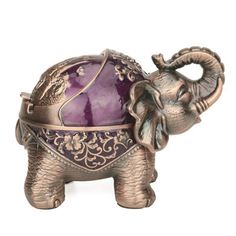 an elephant figurine with a purple ball in its trunk, on a white background