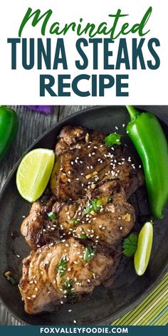 the best marinated tuna steaks recipe on a black plate with green peppers and lime wedges