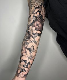 a man's arm with flowers and leaves tattooed on his arm, in black and white