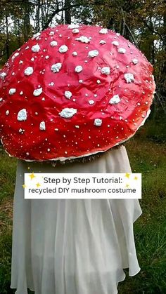 a woman holding a giant red mushroom in her hands with white dots on it's head