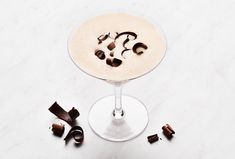 a drink with chocolate pieces around it on a table