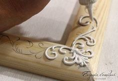 someone is using a carving tool to cut out decorative designs on a piece of wood